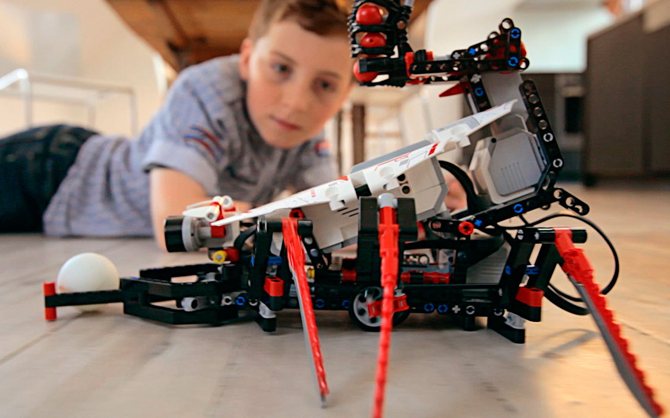کودک در حال ساخت و آموزش برنامه نویسی ربات با کیت LEGO Mindstorms